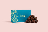 Chocolate raspberries next to a teal box with 'Palm & Vine' branding on a pink background