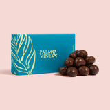 Blue box with a pile of chocolate covered raspberries on a pink background healthy snacking UK