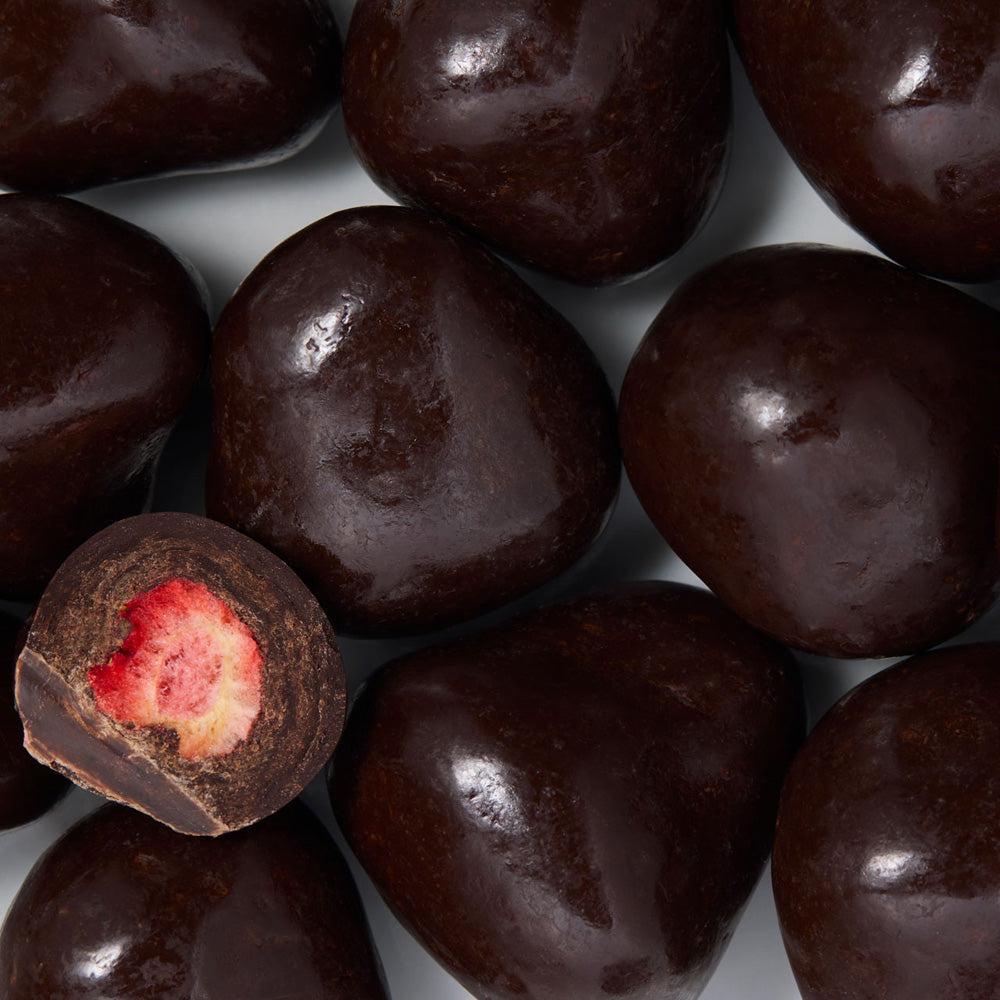 Close-up of dark chocolate strawberries with a single one cut open to reveal a red filling. healthy snacking UK