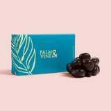 Blue box with 'Palm & Vine' branding next to a cluster of chocolate covered strawberries on a pink background healthy snacking UK
