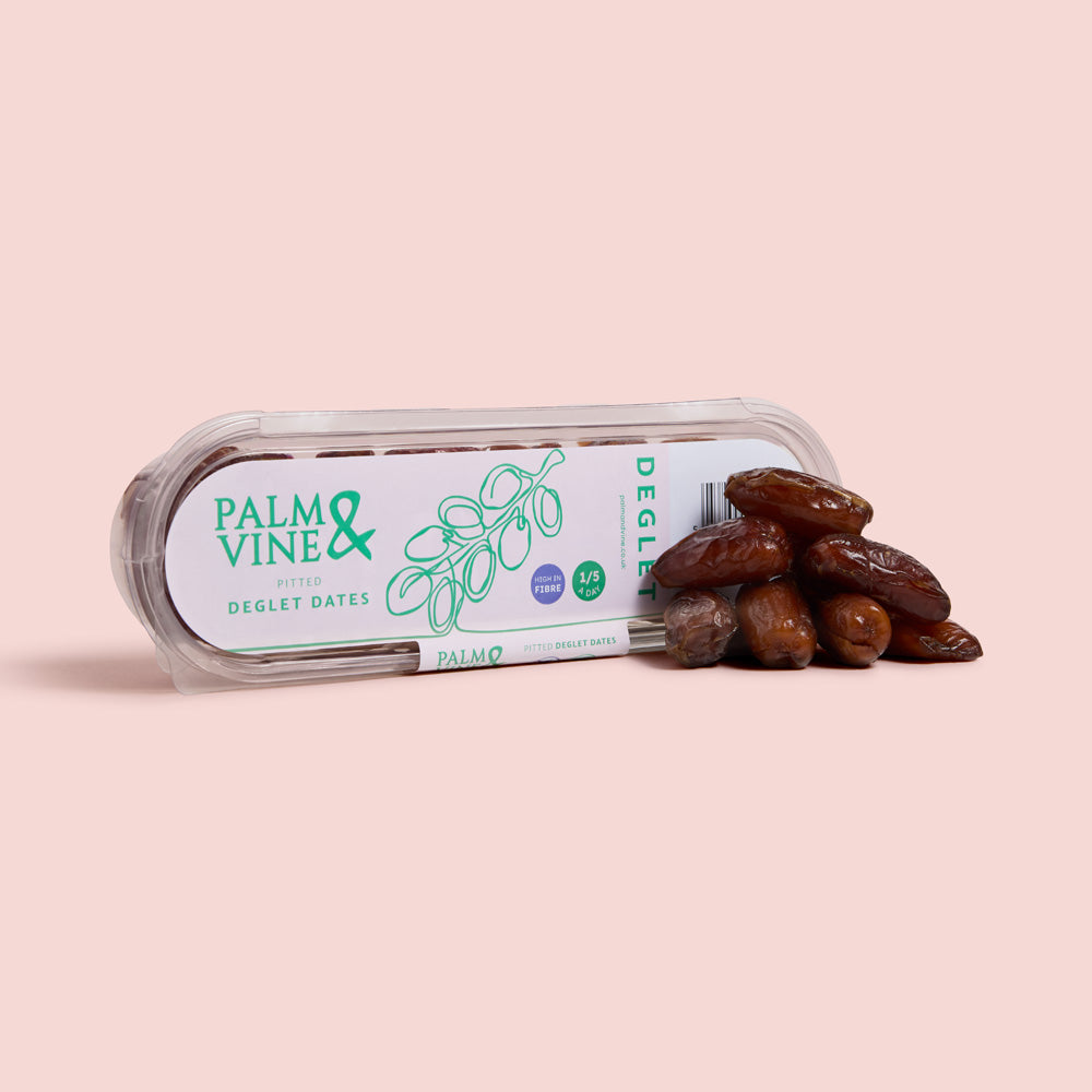 Packaged deglet nour dates with 'Palm & Vine' branding on a pink background healthy snacking UK