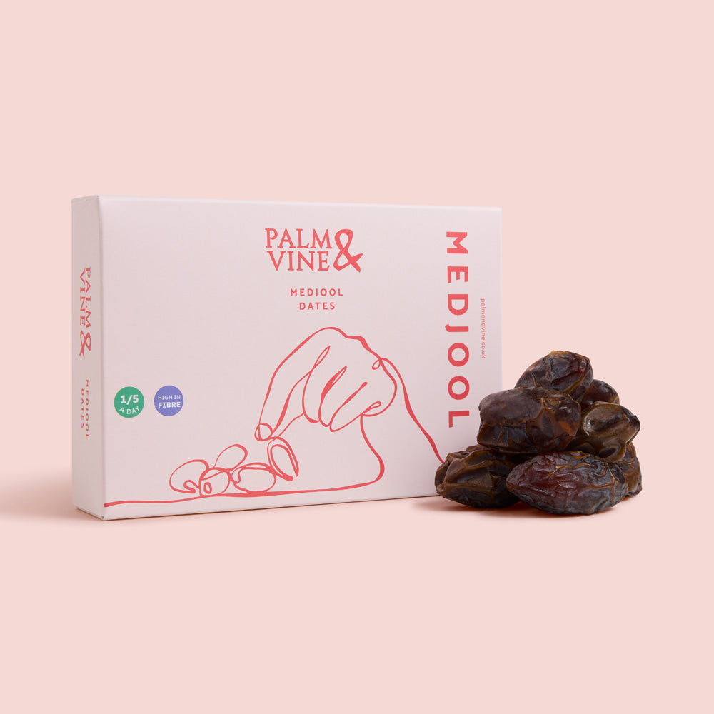 Box of Palm & Vine Medjool dates on a pink background, healthy snacking