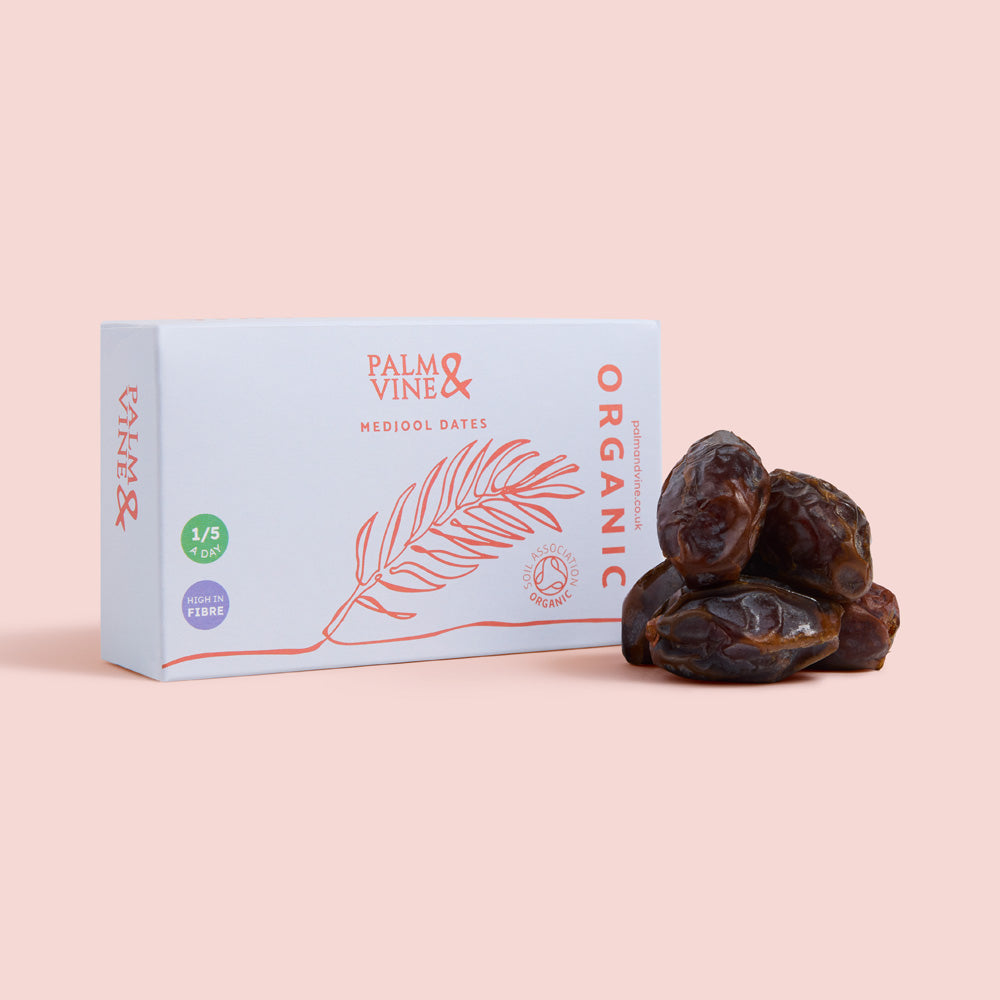 Organic medjool dates and blue Palm & Vine box against pink background healthy snacking UK