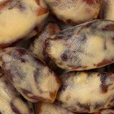 A close-up shot of several peanut butter coated dates piled together.