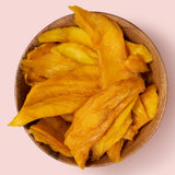 Soft mango slices in brown bowl on pink background healthy snacking UK