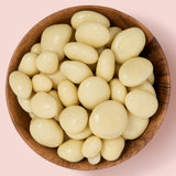 Wooden bowl filled with yoghurt coated cranberries on a pink background healthy snacking UK