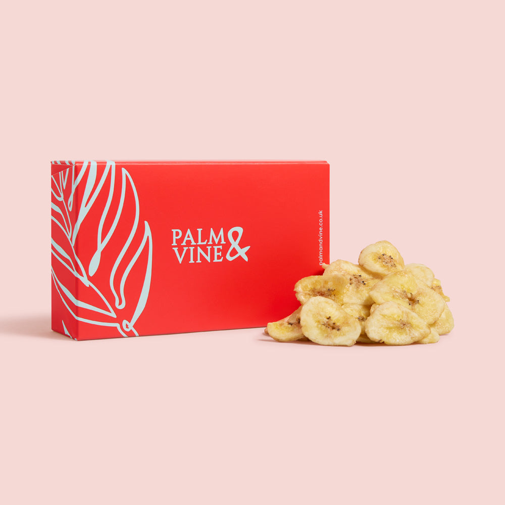 Red box with 'Palm & Vine' branding next to dried bananas on a pink background healthy snacking UK