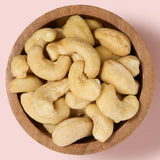 Cashews in a wooden bowl on a pink background  healthy snacking UK