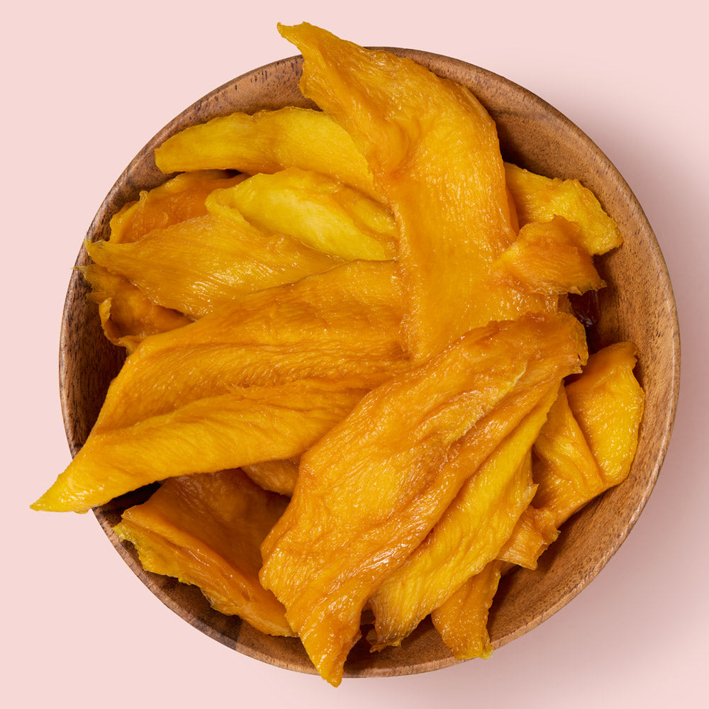 Soft mango slices in brown bowl on pink background healthy snacking UK