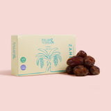 Box of Palm & Vine Zamli dates with dates on a pink background healthy snacking UK